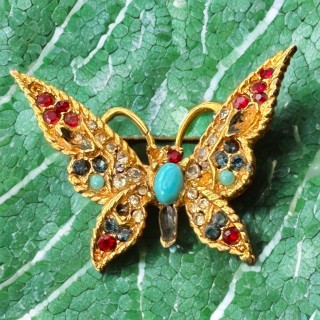 Broche papillon vintage en métal doré et pierres colorées
